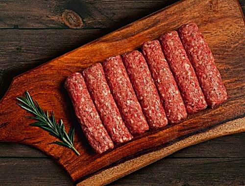 Raw kofta on a wooden board with rosemary
