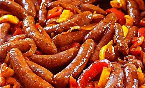 Sausages cooked with colourful peppers